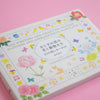 Decorative book with floral and animal illustrations on a pink background