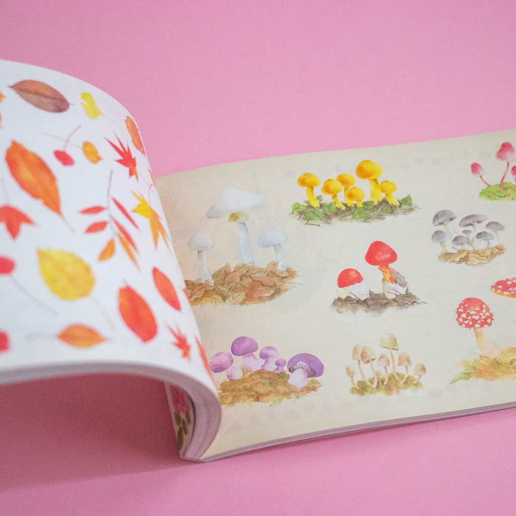 Open book with colorful mushroom illustrations on a pink background
