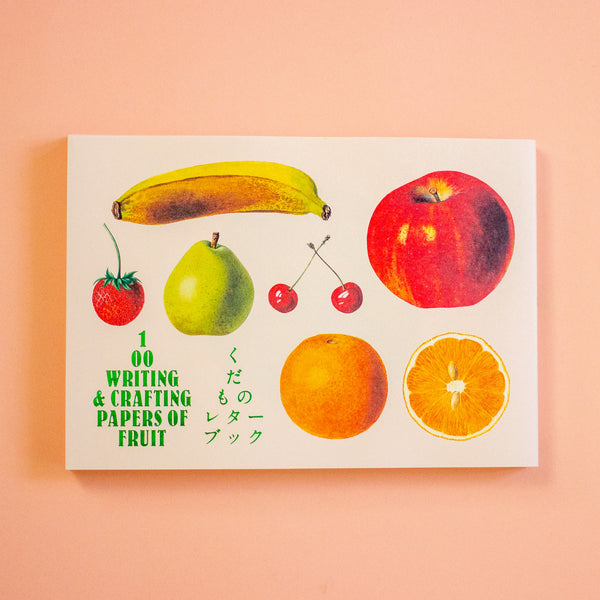 Writing and crafting papers of fruit with illustrations on a peach background