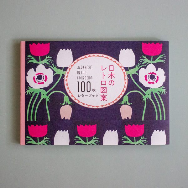 Japanese retro-themed letterbook collection book cover featuring a dark purple background with pink, white, and green floral illustrations, and a central white oval with Japanese and English text.