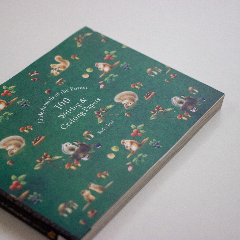 Notebook with forest-themed illustrations on a white background