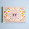 A decorative paper pack box with ornate vintage-style floral and scroll artwork in soft pink, beige, yellow, and green tones, wrapped with a dark ribbon across the center. The box reads '100 PAPERS' and 'WITH CLASSICAL PATTERNS' in English, with additional Japanese text.