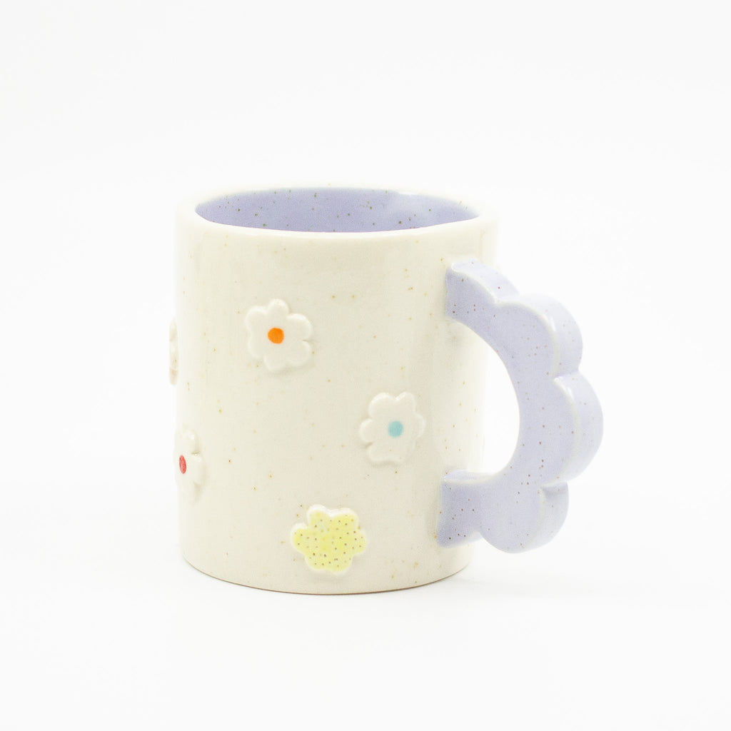 Closeup photo of the Lilac 3D flower mug. Mug has light glaze with lilac interior glaze. Flower shaped handle is lilac coloured. Mug has raised 3D style flowers that are hand painted and glazed in different colours. 