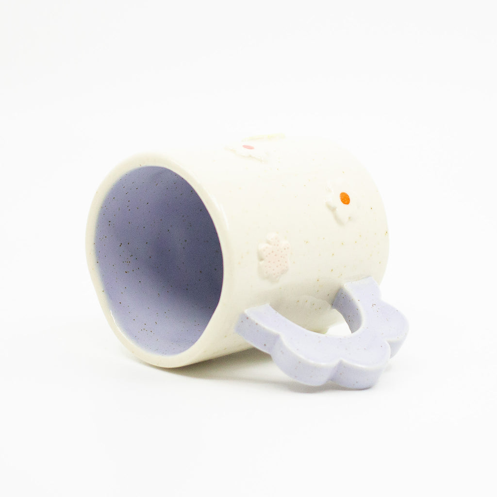 Closeup photo of the interior Lilac 3D flower mug. Mug is lying on its side. Mug has light glaze with lilac interior glaze. Flower shaped handle is lilac coloured. Mug has raised 3D style flowers that are hand painted and glazed in different colours. 
