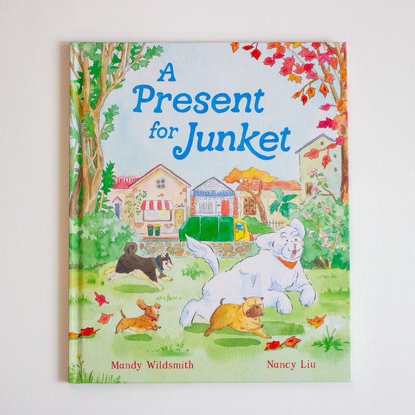Children's book titled 'A Present for Junket' with illustrations of dogs and a house on the cover.