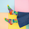 Colorful mosaic-patterned socks on a multicolored geometric background