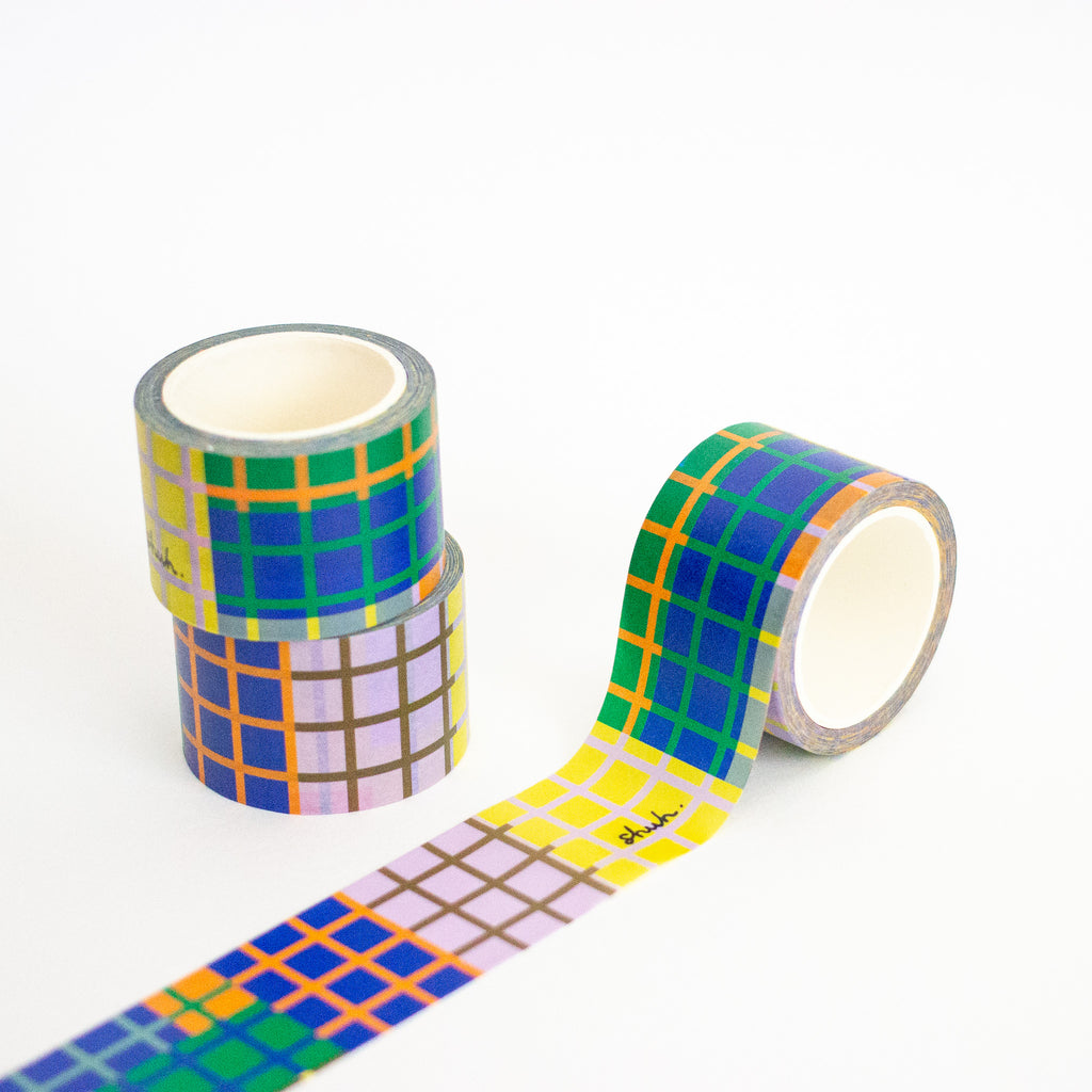 Three rolls of colorful checkered tape on a white background