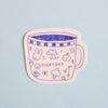 A die-cut sticker featuring a cute blue line art illustration of a mug with the text 'I SLAY EVERYDAY' and small doodles, shown on a light blue background.