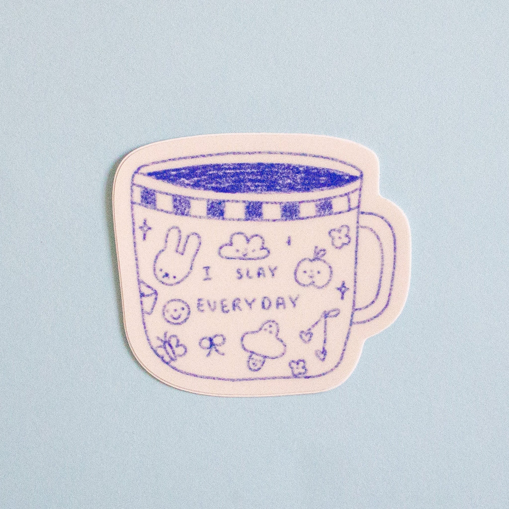 A die-cut sticker featuring a cute blue line art illustration of a mug with the text 'I SLAY EVERYDAY' and small doodles, shown on a light blue background.