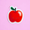 A cute die-cut sticker of a smiling red apple with a green leaf and closed eyes, shown on a solid pink background.