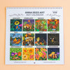 A 2027 spiral-bound Anna Seed Art calendar displayed flat against a peach background. The calendar features 12 square monthly panels with colorful fantasy illustrations, including flowers, mushrooms, and woodland scenes, with labels for each month.
