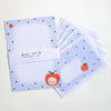 A stationery set featuring light blue paper sheets with dark polka dots, a small red apple illustration, and a white paper band reading 'APPLE BEAR STATIONERY SET'.