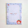 An Apple Bear stationery set in clear plastic packaging, featuring a light blue notepad with dark black polka dots, a cute red apple character, and a white paper band labeled 'APPLE BEAR STATIONERY SET'.