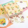 A collection of cute, pastel-coloured stationery items featuring cartoon animal illustrations, including a stack of patterned memo sheets of animal-shaped food, arranged on a white background.