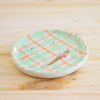 Side view of the aster ceramic pottery soap dish. Green, orange and white tartan paint. Pink tongue and mouth opening. 