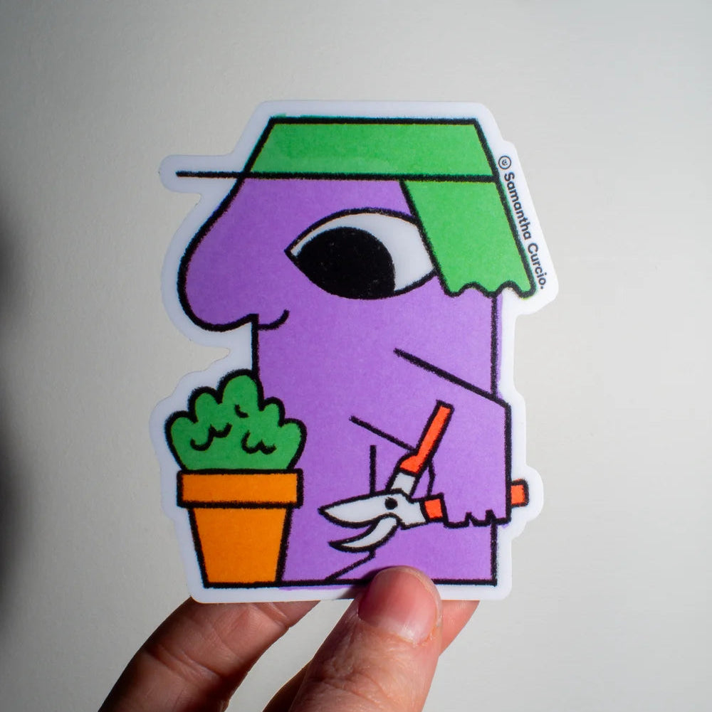 A hand holds a die-cut sticker featuring a stylised purple character with a green hat, holding orange pruning shears next to a potted plant, against a plain light background.