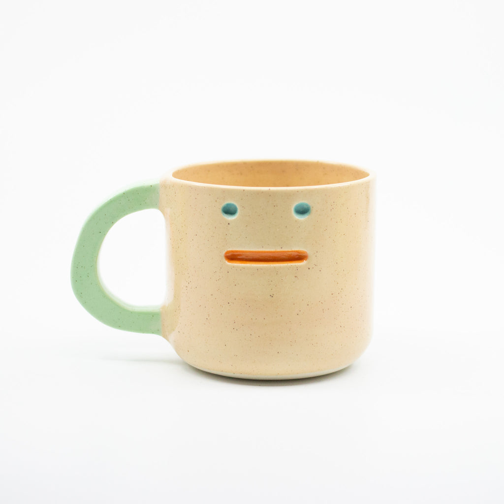 Ceramic mug with a face design on a white background