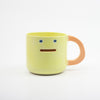 Yellow mug with a smiley face on a white background