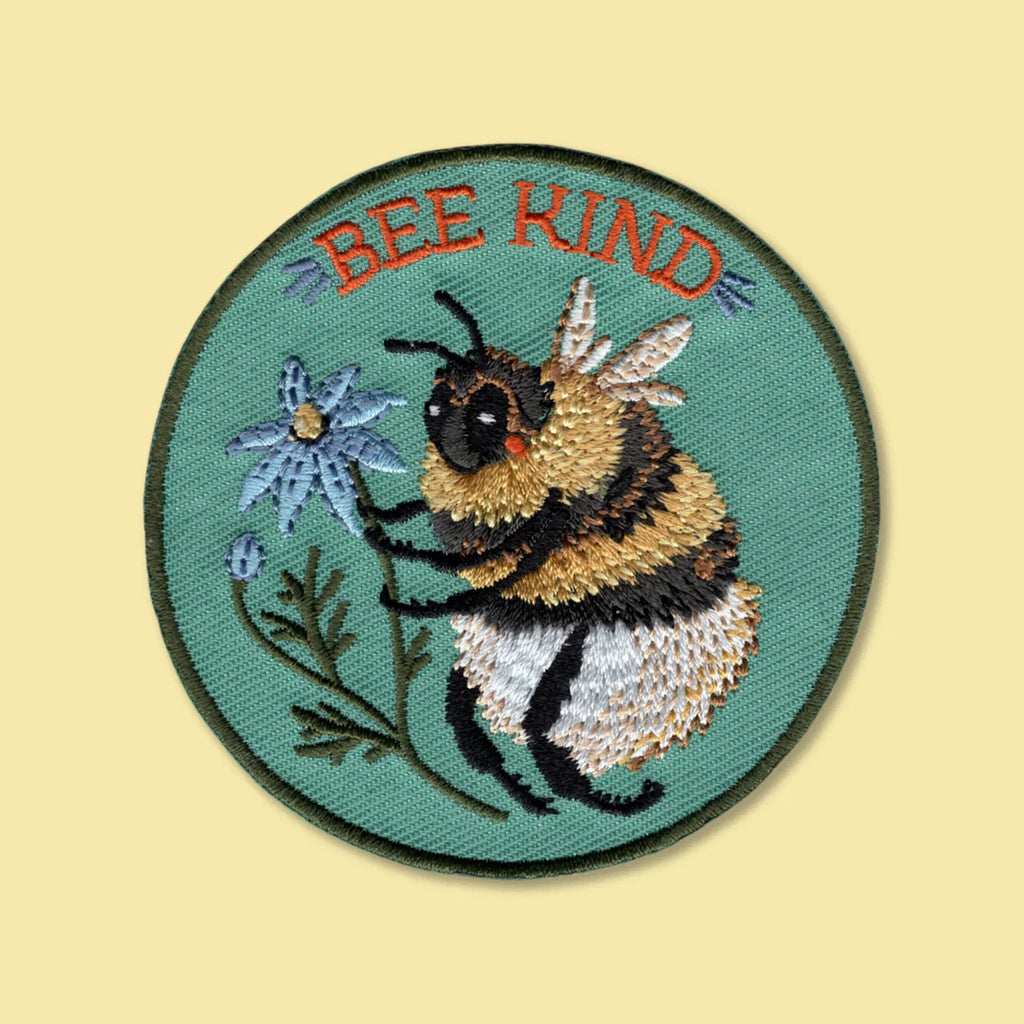 Embroidered patch with a bee and the word 'BEE KIND' on a beige background