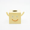 Yellow cube-shaped vase with a smiley face on a white background