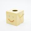 Yellow cube-shaped vase with a smiley face on a white background