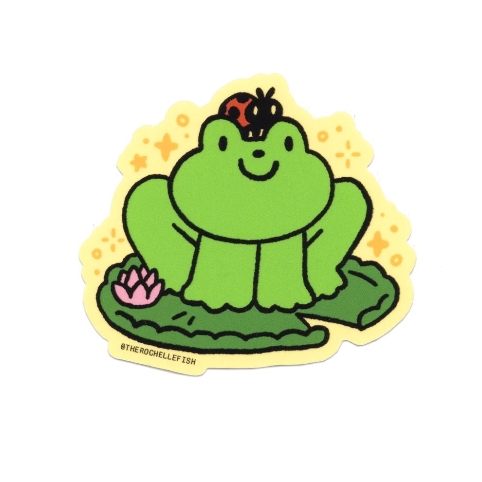 A die-cut sticker featuring a cute cartoon green frog sitting on a lily pad with a pink lotus flower and a ladybug on its head, set against a yellow starry background. The sticker has a yellow border and the handle @THEROCHHELFFISH printed on the bottom left.