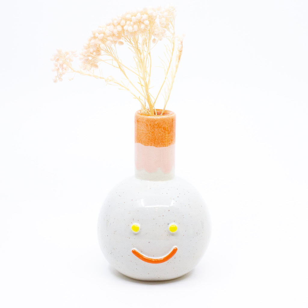 Front view of the Betty vase holding a flower. 