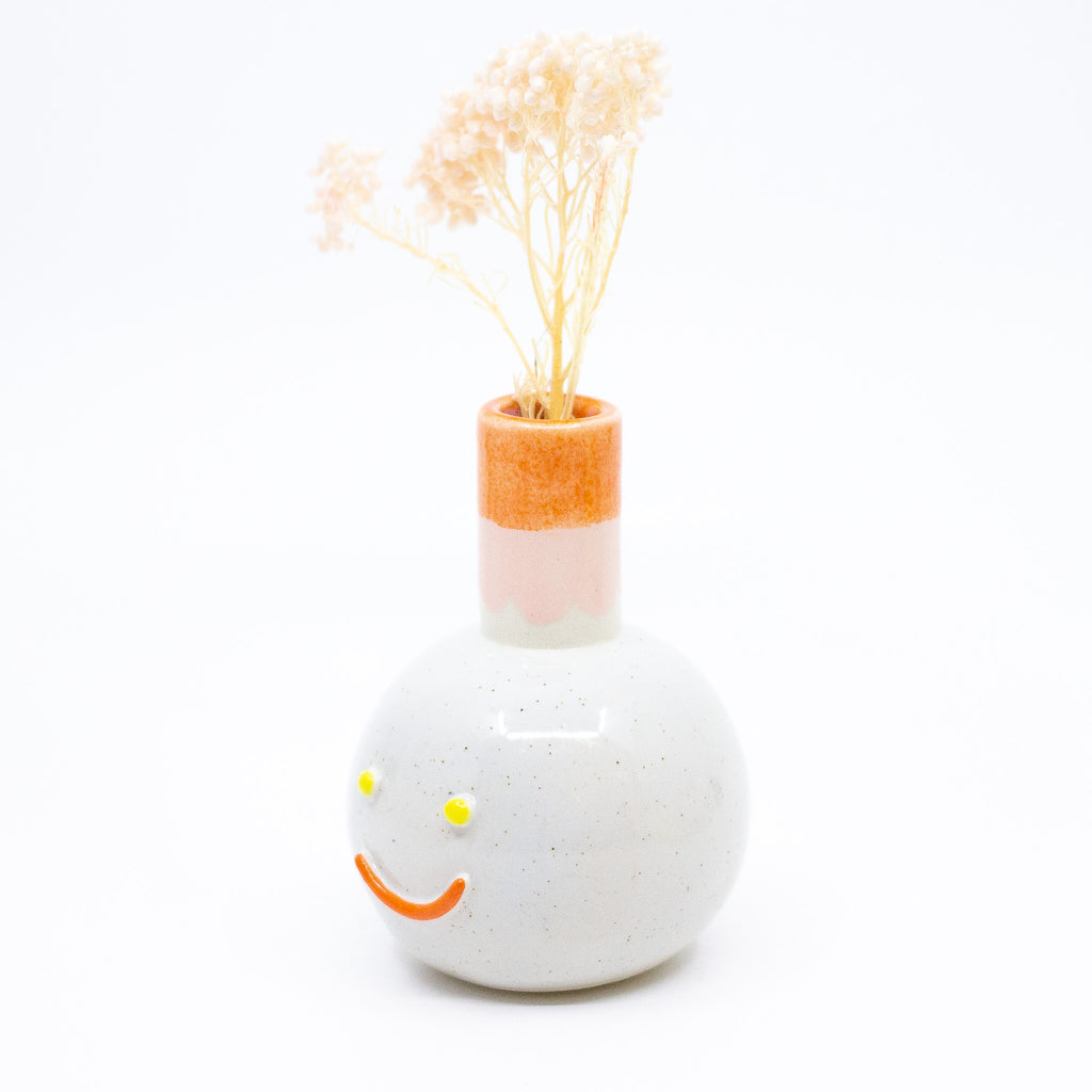 Side view of the Betty vase holding a flower. 