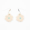 A photo of two bloom earrings with soft pink colouring, and light blue centre. Polka dot effect and sterling silver hooks. 