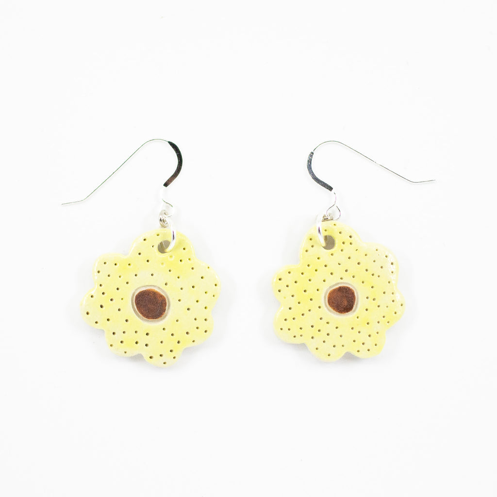 A photo of two bloom earrings with yellow colouring, and brown centre. Polka dot effect and sterling silver hooks. 