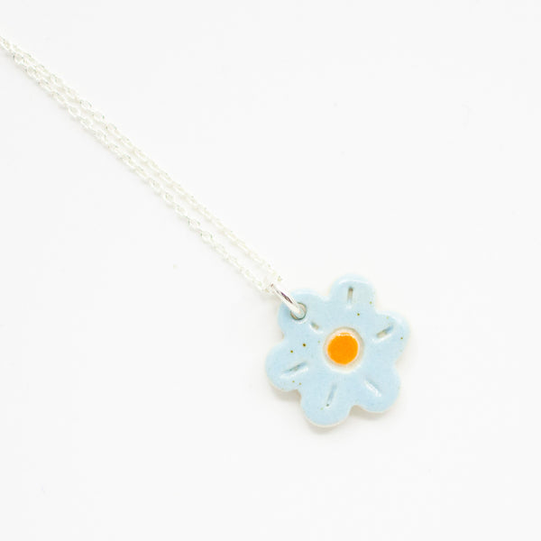 Necklace with a light blue flower pendant on a white background