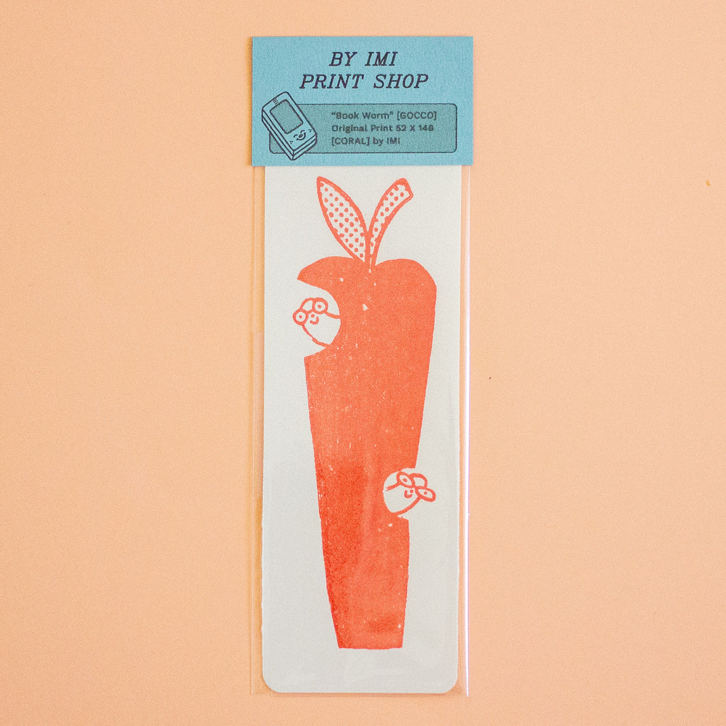 A rectangular white paper print  featuring a stylised red apple illustration with red dotted details, sealed in a clear plastic sleeve with a blue header card that reads 'BY IMI PRINT SHOP'. The product is photographed against a solid peach background.
