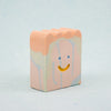 Small rectangular ceramic figure with scallop top and a smiley face design on a light gray background