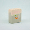 Small rectangular ceramic figure with scallop top and a smiley face design on a light gray background