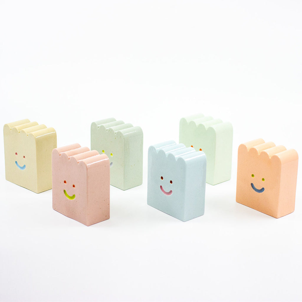 Set of colorful rectangular ceramic figures with smiley face designs on a white background
