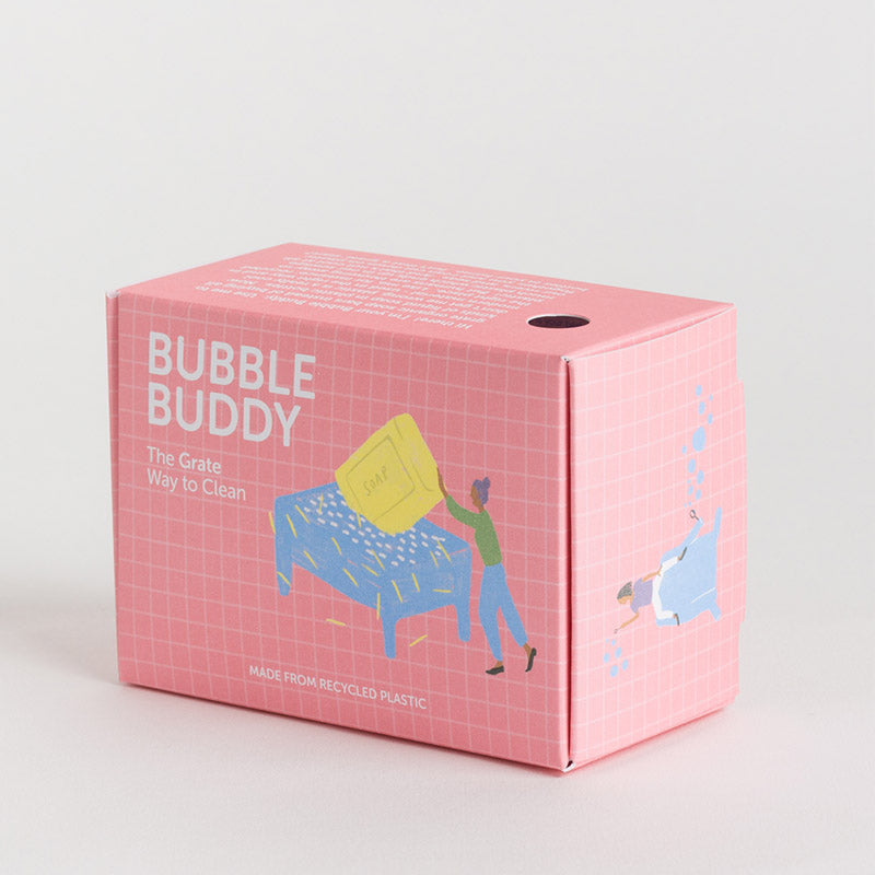A pink cardboard product box with a grid pattern and illustrations of a person cleaning a table, labeled 'BUBBLE BUDDY' and 'The Grate Way to Clean'.