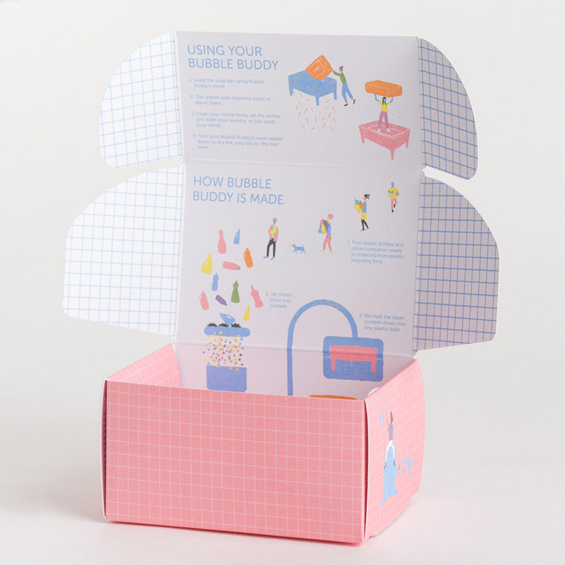 An open pink cardboard box with illustrated instructions on the inside flaps, titled 'Using Your Bubble Buddy' and 'How Bubble Buddy Is Made,' photographed on a clean white background.