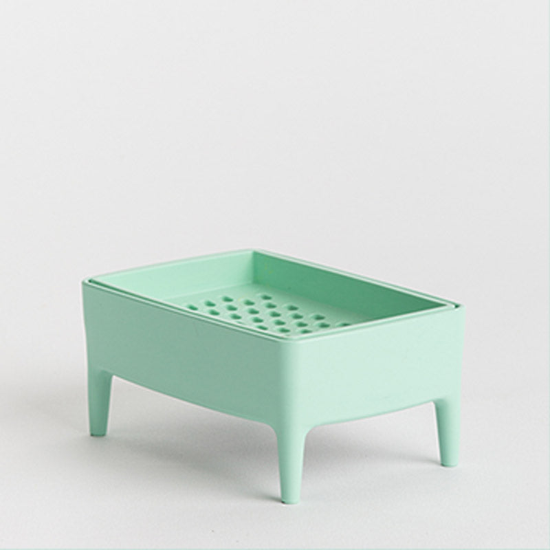 A mint green rectangular plastic tray with legs and a perforated bottom, shown on a clean light grey background.