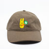 Front view of a dark brown baseball cap with a yellow bunny and green clover embroidered design on a white background