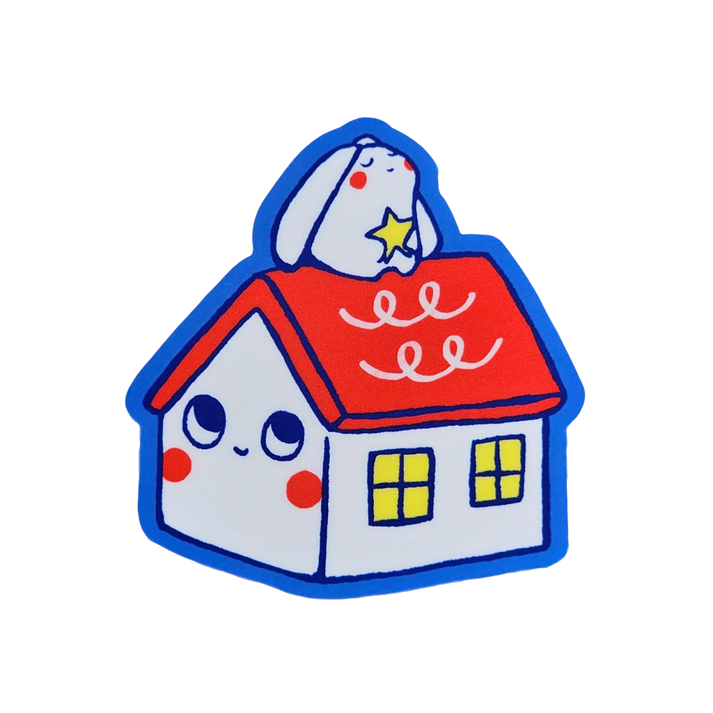 A cute cartoon house sticker or patch featuring a white house with a red roof, blue outline, yellow windows, and a white bunny on top holding a star, shown on a plain white background.