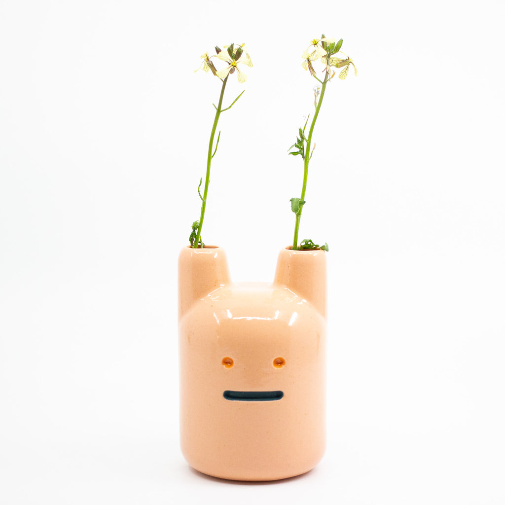 A frontview of the orange ceramic pottery bunny vase