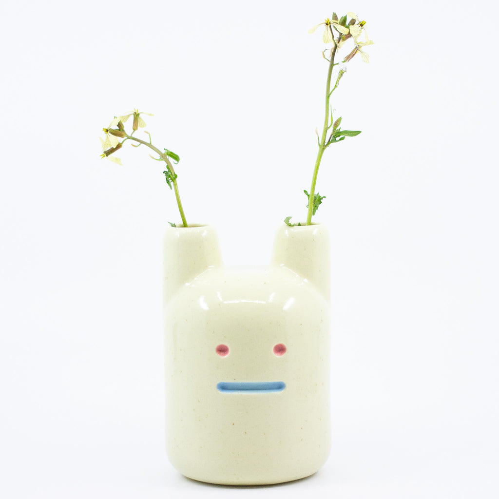 A frontview of the yellow ceramic pottery bunny vase. 