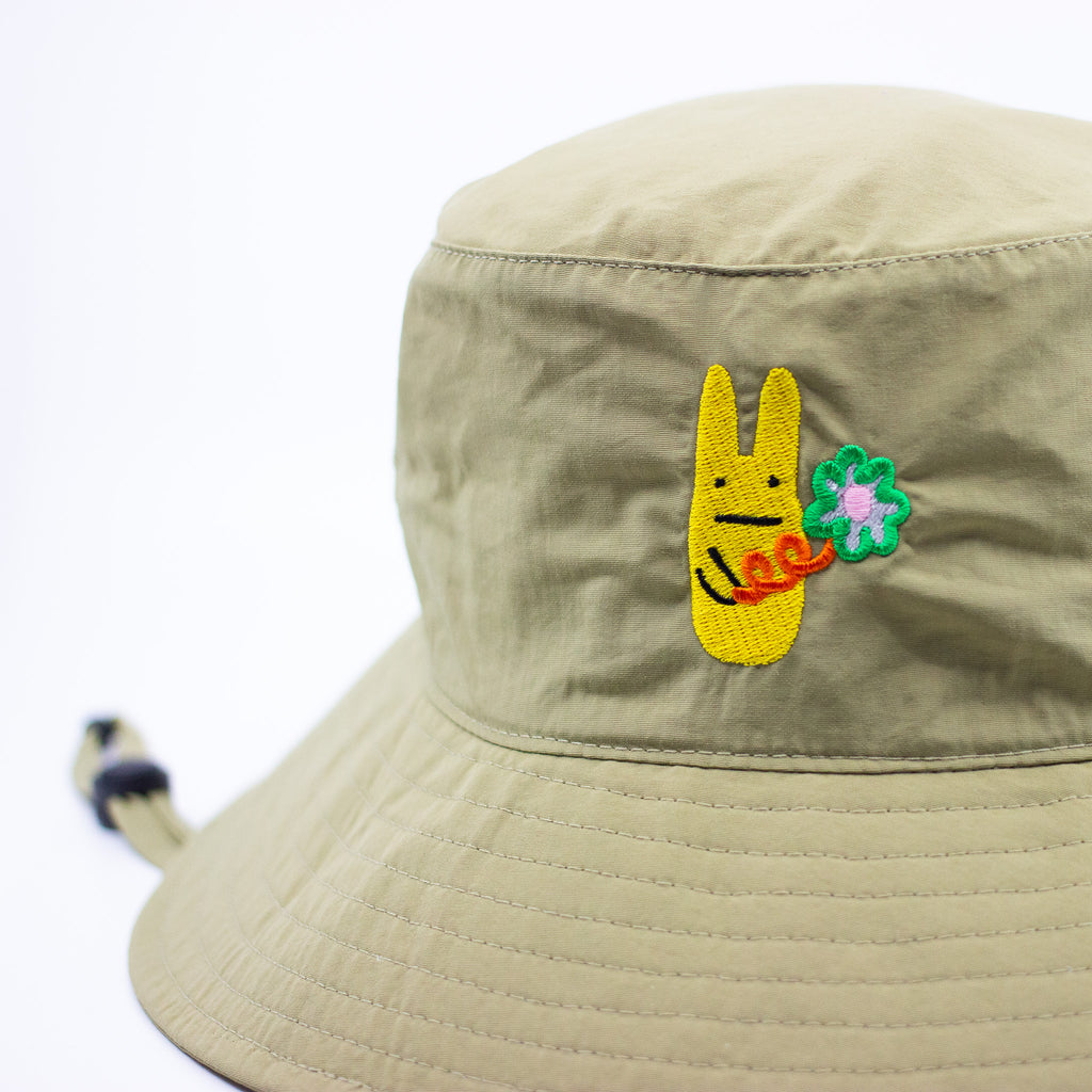 Beige bucket hat with a colourful embroidered bunny design on a white background