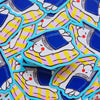 A pile of colourful die-cut stickers featuring a cartoon illustration of a white bunny under an open book, on a pink and yellow striped cushion. The stickers have a bright blue border.