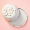 Lid with 'BUTT' text on a peach background