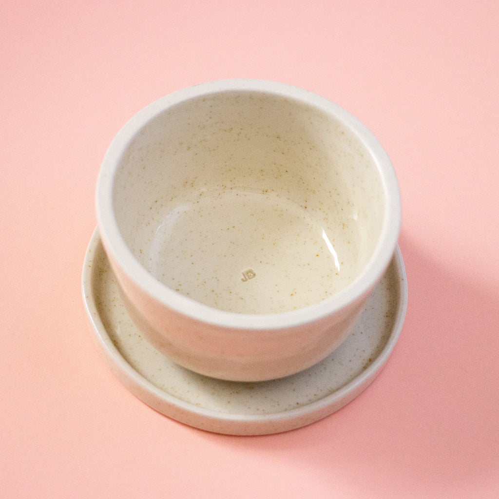 Ceramic bowl and saucer set on a peach background