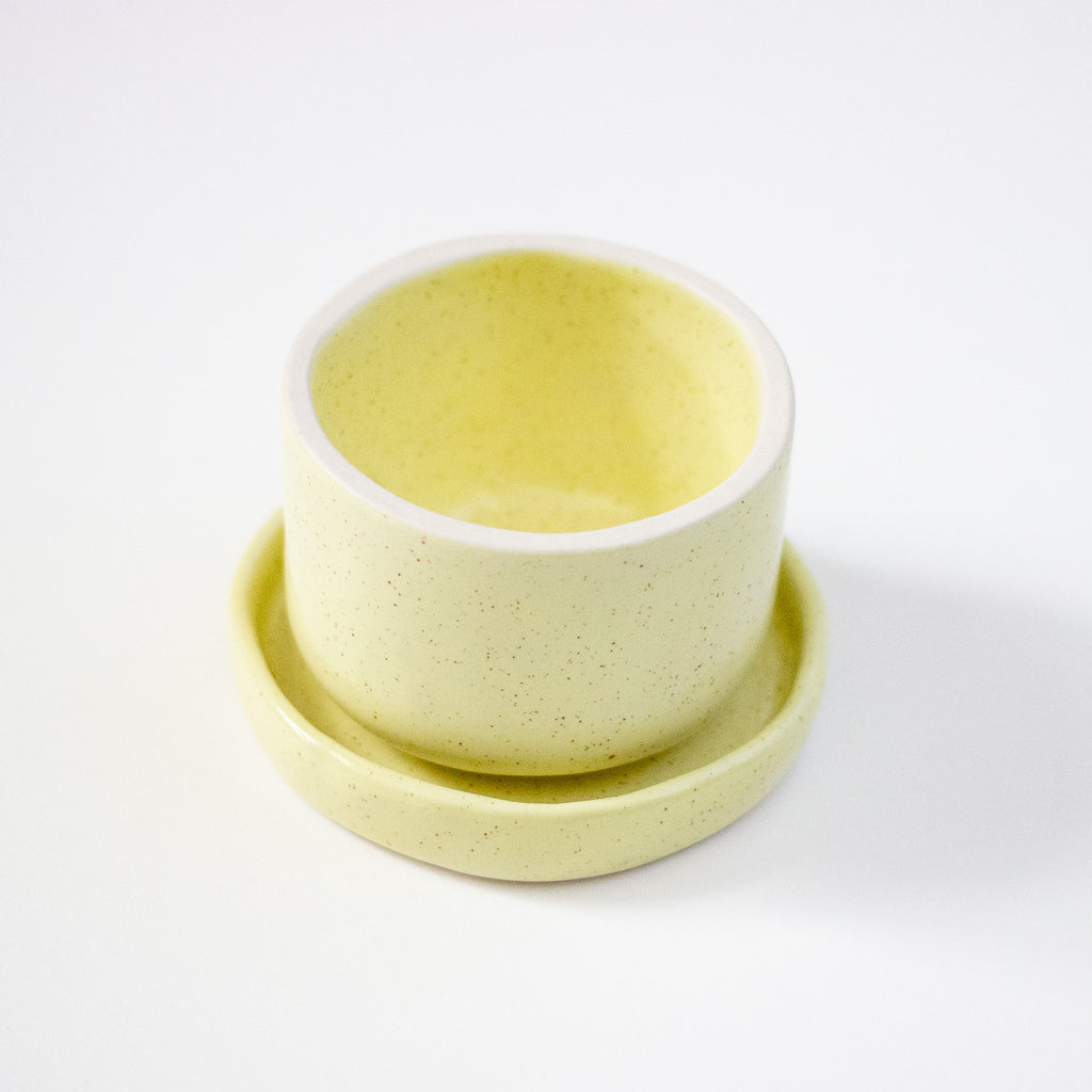 Two light yellow ceramic bowls on a white background