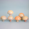 Set of colorful mushroom-shaped figurines on a light blue background