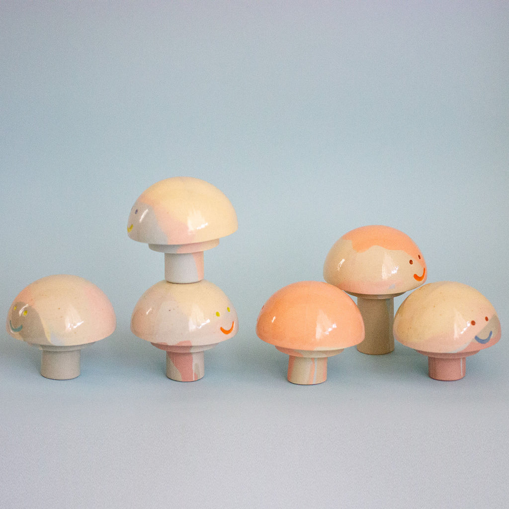 Set of colorful mushroom-shaped figurines on a light blue background