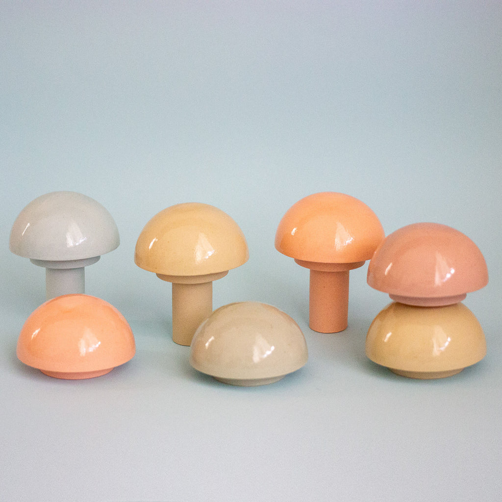 Set of six colorful mushroom-shaped objects on a light blue background